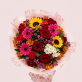 Arreglo Buchón Primaveral con rosas rojas, girasoles y gerberas fucsia