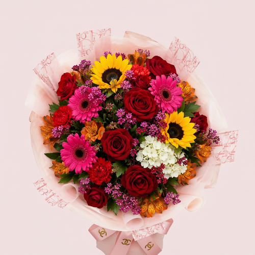 Arreglo Buchón Primaveral con rosas rojas, girasoles y gerberas fucsia