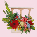 Ventana Floral con gerberas rojas, rosas crema, lirios y eucalipto en ventana de madera
